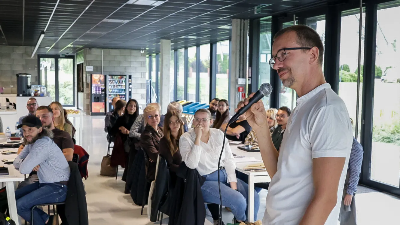 Wystąpienie z mikrofonem przed uczestnikami szkolenia w przeszklonej sali Hali LUX w Rogoźniku - cykl KULTURA JUTRA, 21 września 2026