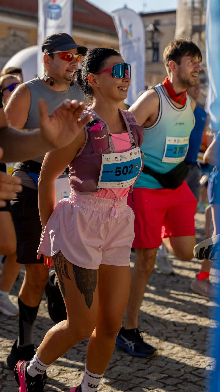 Wolontariuszka trzyma transparent kibicujący na trasie półmaratonu w Tarnowskich Górach