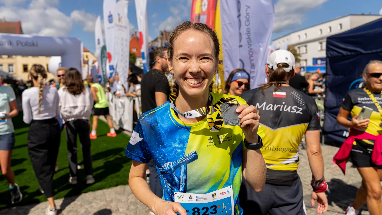 Trójka biegaczy z medalami po Tarnogórskim Półmaratonie na rynku - fotografia grupowa