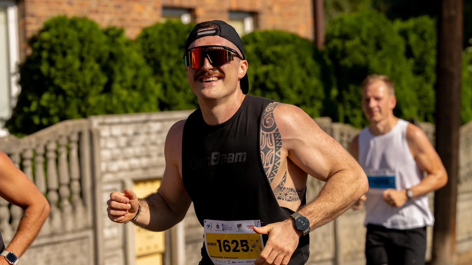 Dwaj biegacze pozują w koszulkach 7. PKO Tarnogórski Półmaraton - fotografia sportowa