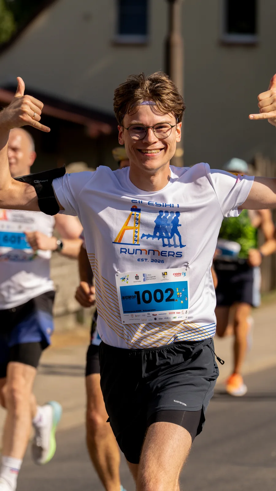 Uczestnicy Tarnogórskiego Półmaratonu 2026 z medalami na trasie - fotograf eventowy